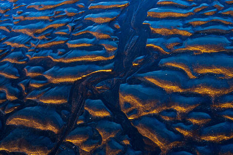 Reflections in the sand on the black sand beach below Vesterhorn Mountain in southeast Iceland. 