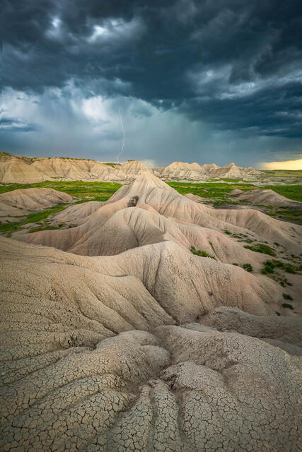 Toadstool Badlands in Nebraska under a summer thunderstorm with a distant lightning strike.